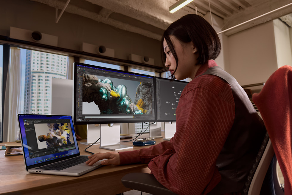 MacBook Pro connected to two external displays at a desk